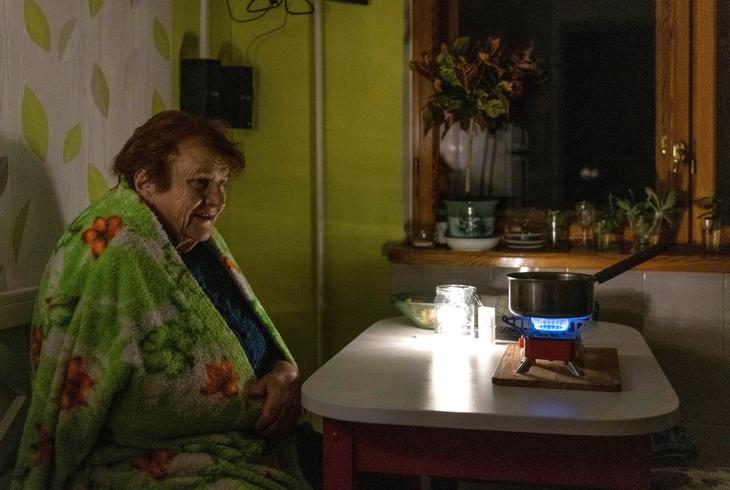 Tábori gázégőt használ egy idős nő a kijevi otthonánk konyhájában áramszünet alatt.  Fotó: MTI/AP