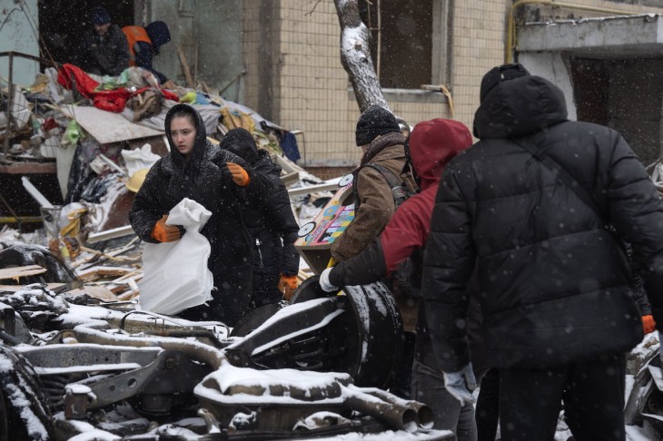 Romos házból viszik el ingóságaikat lakók Kijevben az ukrán fővárost előző nap ért orosz rakétatámadás után. Fotó: MTI/AP/Efrem Lukackij