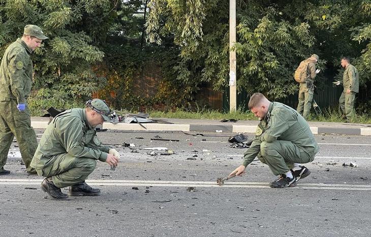Az orosz Nyomozó Bizottság által közreadott, videófelvételről készített kép nyomozókról az Alekszandr Dugin orosz ultranacionalista ideológus lánya, Daria elleni pokolgépes merénylet helyszínén Moszkvában 2022. augusztus 21-én. Dariával feltételezhetően pokolgépes merénylet végzett előző este. A hatósági gyanú szerint a pokolgépet a Daria Dugina vezette terepjáró gépkocsiba rejtették el, és az menet közben felrobbant. MTI/AP/Orosz Nyomozó Bizottság