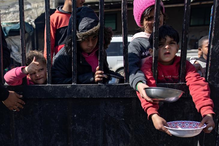 Menekült palesztin gyerekek várnak élelemosztásra egy rafahi menekülttáborban a Gázai övezetben 2024. február elsején. 