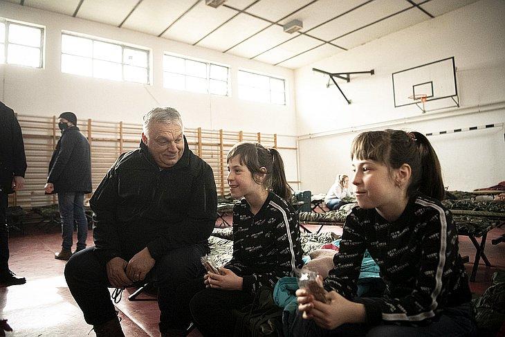 A Miniszterelnöki Sajtóiroda által közreadott képen Orbán Viktor miniszterelnök gyerekekkel beszélget a háború miatt Ukrajnából Magyarországra menekülők számára kialakított segítségponton Beregsurányban 2022. március 3-án. (Fotó: MTI/Miniszterelnöki Sajtóiroda/Benko Vivien Cher)