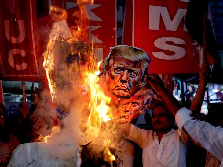 Indiai ellenzéki aktivisták Donald Trump gúnymaszkját égetik, tiltakozásul az Indiára kivetett amerikai büntetővámok ellen