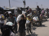 Az amerikai hátterű Gázai Humanitárius Alap segélyszervezet által kiosztott, élelmiszert és egyéb segélyt tartalmazó zsákokat cipelnek palesztinok a Gázai övezet déli részén fekvő Rafahban 2025. június 16-án. 