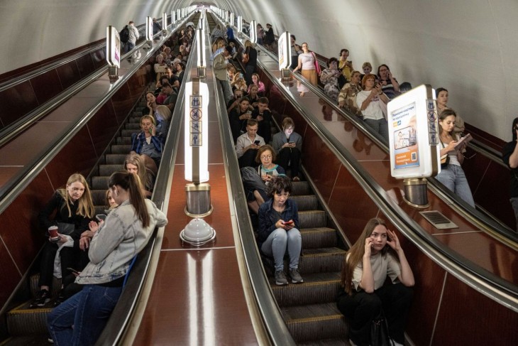 Emberek várakoznak egy óvóhelyként használt kijevi metróállomás mozgólépcsőjén egy orosz légitámadás alatt 2023. május 29-én. Fotó: MTI/AP