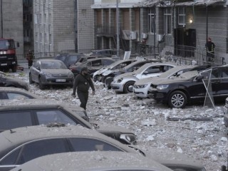 Épülettörmelékkel borított parkolón vág át egy rendőr egy orosz dróntámadás után Kijevben 2023. május 30-án. A támadásban egy ember életét vesztette, hárman megsérültek. Fotó: MTI/AP/Roman Hrytsyna
