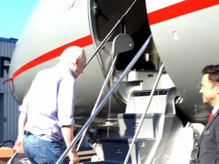 Julian Assange beszáll egy repülőgépbe a londoni Stansted repülőtéren 2024. június 24-én 