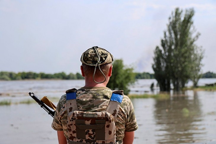 Gátrobbantás okozta árvizet néz egy ukrán katona Herszonban 2023. június 6-án. Fotó: MTI/EPA/Ivan Antipenko