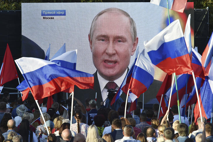 Orosz zászlókat lengető emberek ünnepelnek Moszkvában 2022. szeptember 30-án, miután Vlagyimir Putyin orosz elnök bejelentette a négy kelet-ukrajnai régió Oroszországhoz csatolását.  Fotó: MTI/AP 