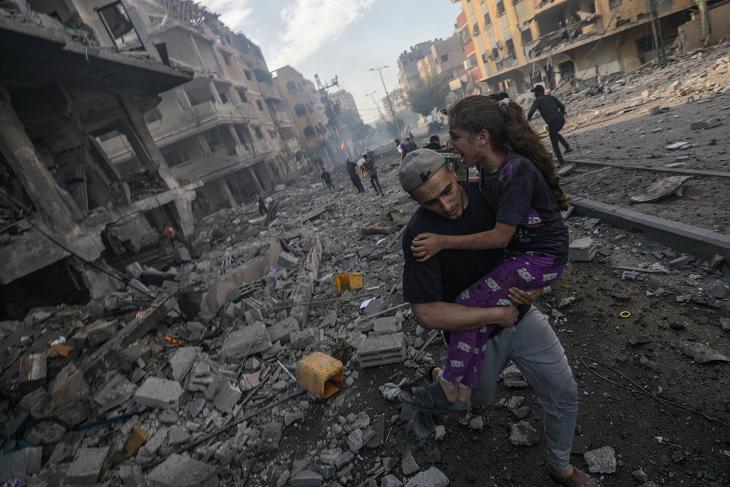 Egy férfi visz karjaiban egy sérült lányt Gázavárosban egy izraeli légicsapást követően. Fotó: EPA/MOHAMMED SABER