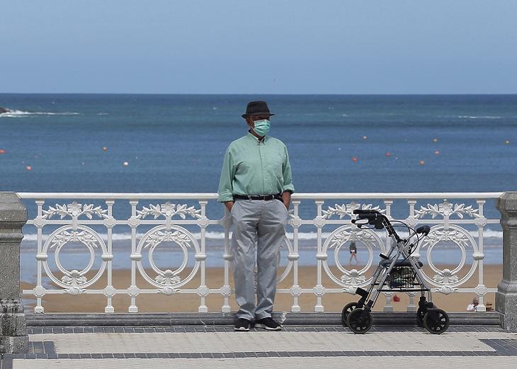 Egy idős ember maszkban a la Concha strandon Donostiban Baszkföldön 2020. május 24-én. EPA/Gorka Estrada