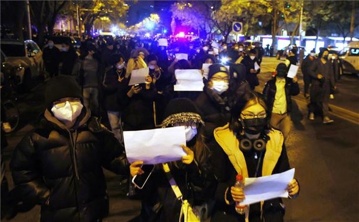 Tüntetők vonulnak Pekingben 2022. november 27-én. A tüntetők a kínai kormány koronavírus elleni óvintézkedései miatt tiltakoznak azt követően, hogy november 24-én a nyugat-kínai Hszincsiang-Ujgur Autonóm Terület székhelyén, Ürümcsiben kigyulladt egy 15 emeletes lakóépület. A tűzben - amelyet a vizsgálat szerint egy meghibásodott konnektor okozott - tízen életüket vesztették, és többen megsérültek. Az interneten keringő hírek szerint az áldozatok száma azért volt ilyen magas, mert az épületet részleges vesztegzár alá helyezték, és a lakók nem tudtak időben kimenekülni. Városi tisztségviselők ezt tagadták. A négymillió lakosú Ürümcsiben vannak, akik már száz napja karanténban vannak. Fotó: MTI/EPA/Mark R. Cristino