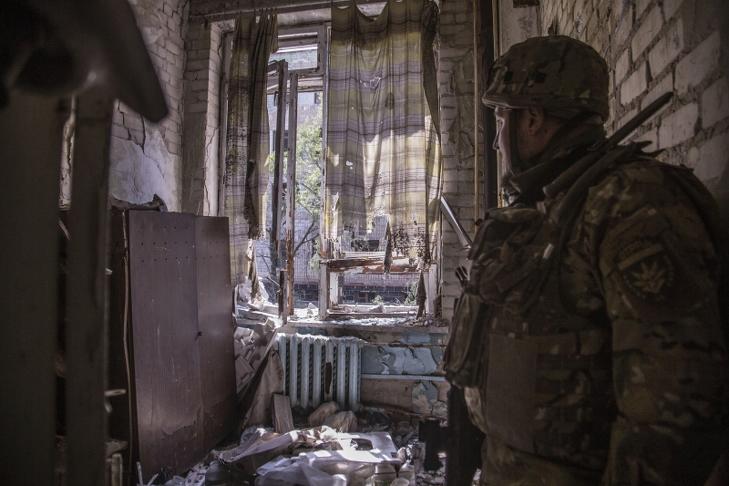 Ukrán katona egy lőállásnak használt épületben Szeverodoneckben. Fotó: MTI/AP/Olekszandr Ratusnyak