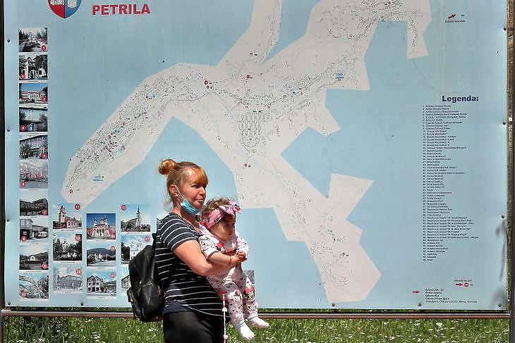 Nő gyermekével a romániai Petrilában 2020. július 14-én. EPA/ROBERT GHEMENT