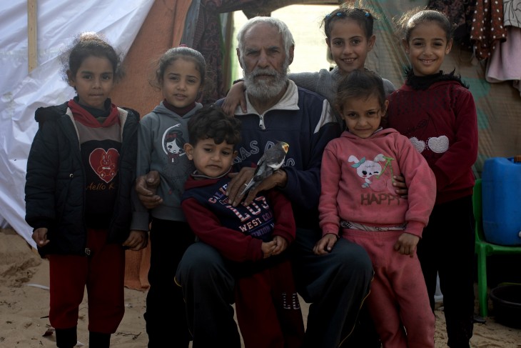 Palesztin család a Gázai övezet déli részén fekvő Rafahban, egy menekülttáborban 2024. január 11-én. Ők még élnek, de több száz gázai családot már teljesen eltüntettek a Föld színéről az izraeli támadások. Fotó: EPA/HAITHAM IMAD 