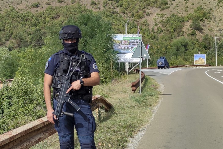 Koszovói rendőr Banjska falunál, Pristinától 55 kilométerre, északra 2023. szeptember 24-én, miután reggelre virradóan ismeretlen tettesek koszovói rendőrökre támadtak a koszovói Mitrovica város hídján. Éjjel két, rendszámtábla nélküli teherautó elzárta a forgalmat a hídon, majd valahonnan rálőttek a kiérkező rendőrökre. A tűzharcban két rendőr megsebesült, egyikük belehalt sérüléseibe. Albin Kurti koszovói miniszterelnök és Vjosa Osmani koszovói elnök szerb bűnbandákat gyanúsít a lövöldözéssel. Fotó: MTI/AP/Dejan Simicevic 