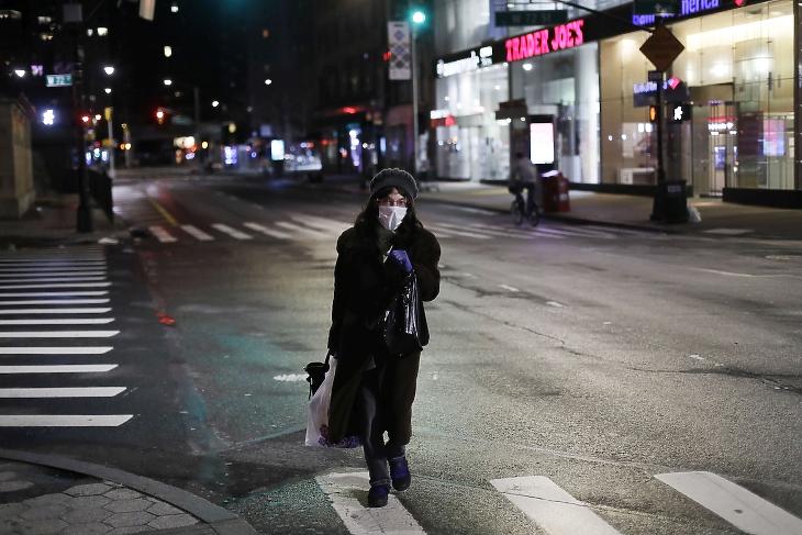 Magányos járókelő a New York-i Broadwayn a koronavírus-járvány idején, 2020. április 13-án este. A sohasem alvó városként is emlegetett New York utcái többnyire néptelenek a járvány miatt. MTI/AP/Mark Lennihan