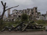 Lőszerekkel teli dobozok egy elpusztult iskolaépület maradványai előtt az ukrán fennhatóság alá visszakerült dél-ukrajnai Herszon közelében.