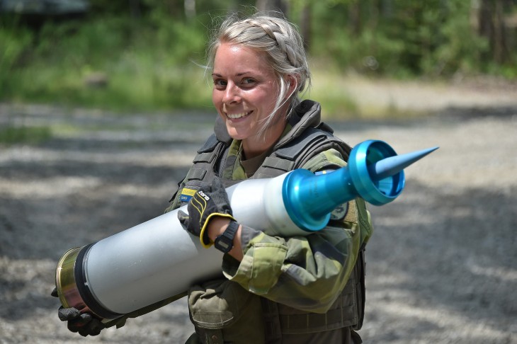Svéd katonanő egy páncéltörő harckocsilőszerrel a kezében egy 2018-as hadgyakorlaton. A lényeg a lőszerből kiálló tüske: ez csapódik be iszonyatos energiával a tank páncélzatába. Fotó: Wikimedia