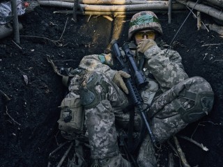 Ukrán katona ül egy lövészárokban a donyecki régióban fekvő, ostromgyűrűben lévő Bahmutban 2023. március 5-én. Bahmutot az ukrán védelmi erők tartják ellenőrzésük alatt, míg az orosz egységek erőiket a környező települések irányában történő támadó műveletek végrehajtására összpontosítják. Fotó: MTI/AP/Libkos 