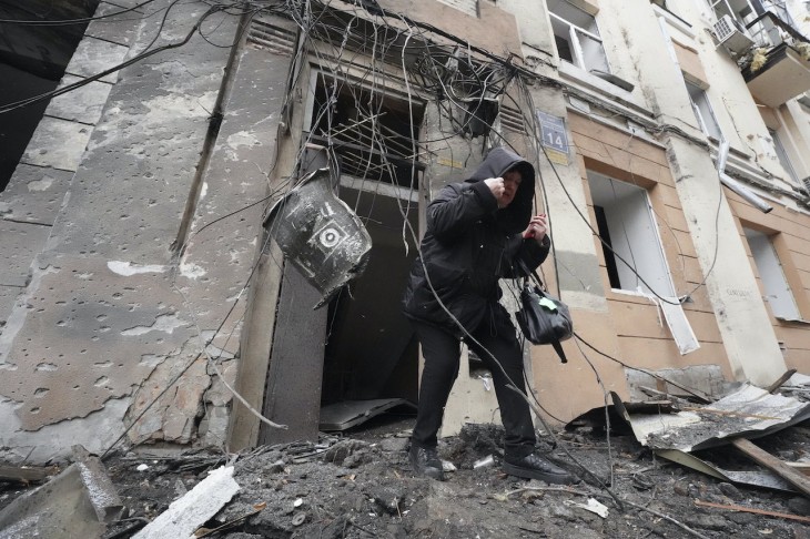 A 2023. február 5-i képen orosz tüzérségi támadástól súlyosan megrongálódott lakóépületből távozik egy nő az északkelet-ukrajnai Harkiv nagyvárosban. Fotó: MTI/AP/Andrij Marienko
