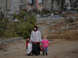 Egy palesztin nő menekül gyerekeivel a Gázai övezet déli részére a Salah Al Din úton 2023. november 28-án. Fotó: EPA/MOHAMMED SABER 