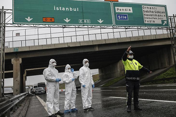 Egy buszt állít meg egy rendőrtiszt, hogy egészségügyi szakemberek megmérjék az utasok testhőmérsékletét Isztambulban 2020. március 29-én. Illusztráció. MTI/AP/Emrah Gürel