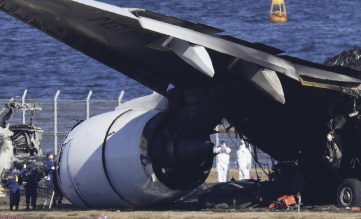 Nyomozók vizsgálják a Japan Airlines kiégett utasszállítójának roncsait tokiói Haneda repülőtéren 2024. január 4-én. Az utasszállító két nappal korábban 367 utassal és a 12 fős személyzettel a fedélzetén landolás közben megcsúszott az aszfalton, összeütközött a parti őrség egyik repülőgépével, majd kigyulladt. A balesetben a parti őrség öt tagja életét vesztette.
