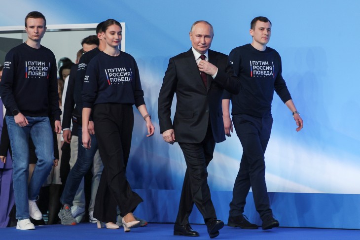 Duzzadó önbizalom: Vlagyimir Putyin érkezik fiatalokkal körülvéve moszkvai kampányközpontjába a választás másnapján,  2024. március 18-án.