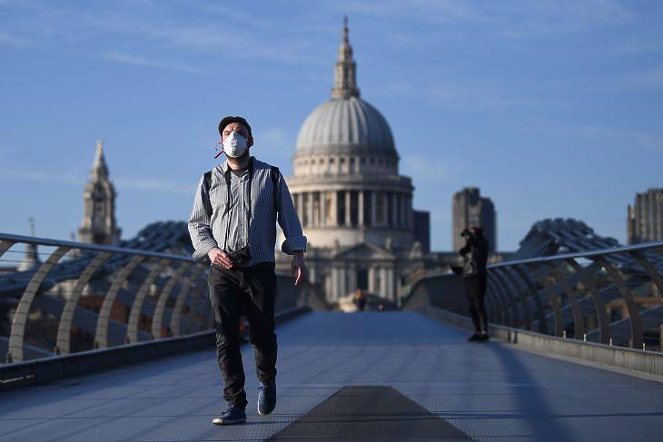 Védőmaszkot viselő férfi a Szent Pál katedrális előtt Londonban 2020. március 26-án.  EPA/NEIL HALL
