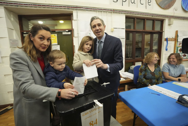 Simon Harris ír miniszterelnök, a kereszténydemokrata Fine Gael párt vezetője és felesége, Caoimhe voksol gyerekeikkel az írországi előrehozott parlamenti választásokon a Wicklow megyei Delganyban 2024. november 29-én