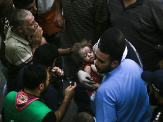Palesztinok visznek be az Al-Shifa kórházba egy sérült kisgyereket az izraeli légicsapások után Gázavárosban 2023. október 9-én. Fotó: EPA/HAITHAM IMAD 