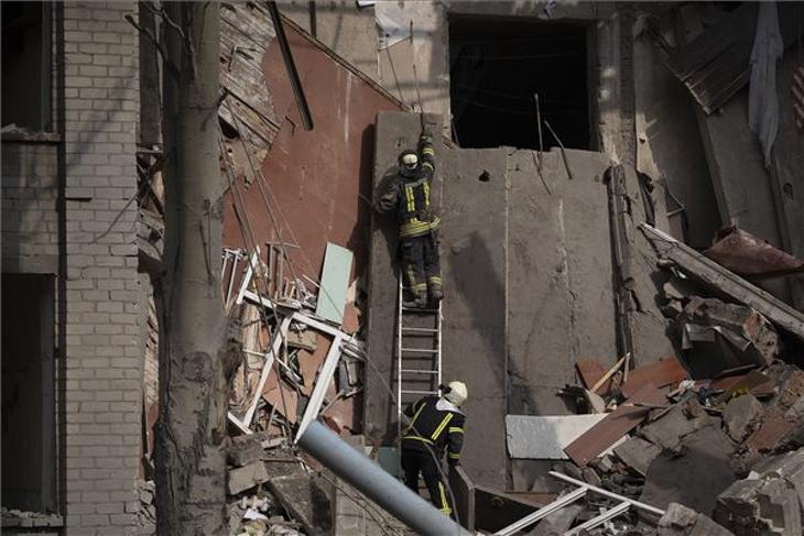 Mentőalakulatok tagjai egy orosz támadásban megrongálódott iskolaépület romjai között a dél-ukrajnai Mikolajvkában 2022. szeptember 28-án. Fotó: MTI/AP/Leo Correa