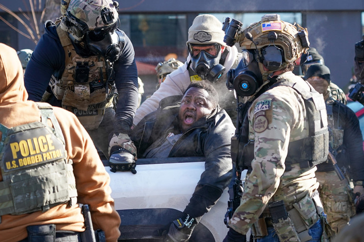 A Bevándorlási és Vámvégrehajtás (ICE) szövetségi hatóság ellen tüntetők egyikét őrizetbe veszik rendőrök Minneapolisban 2026. január 24-én, miután a szervezet egyik ügynöke halálosan megsebesített egy 37 éves férfit, Alex Prettit, aki a hatóságok szerint felfegyverkezve jelent meg egy bevándorlási razzián a Minnesota állambeli városban