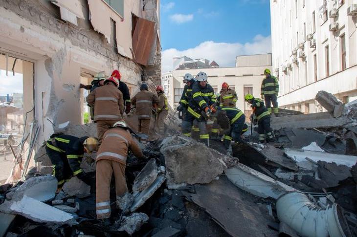 Mentőalakulatok tagjai túlélőket keresnek egy tüzérségi támadásban megrongálódott lakóház romjai között Harkivban 2022. március 18-án. Fotó: MTI/EPA