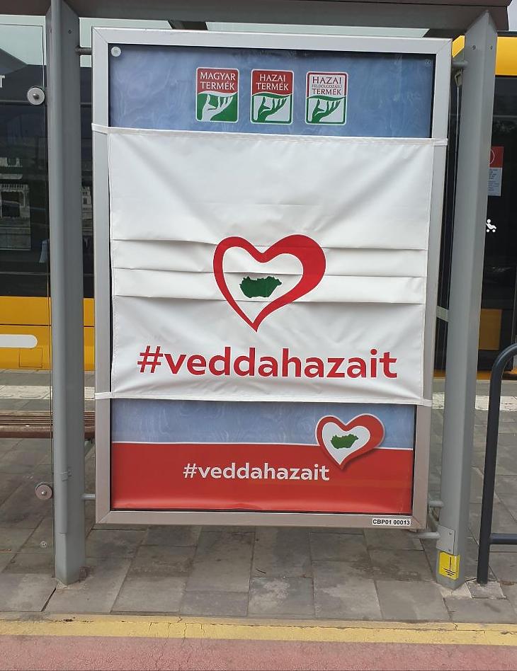 Szájmaszkkal fedett citylight posztereken hirdetik a magyar árut