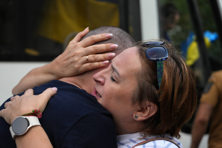 Orosz hadifogságból kiszabadult ukrán férfit ölel hozzátartozója, miután a férfi egy hadifoglyokat szállító különbusszal ukrán fennhatóságú területre érkezett 2024. szeptember 13-án
