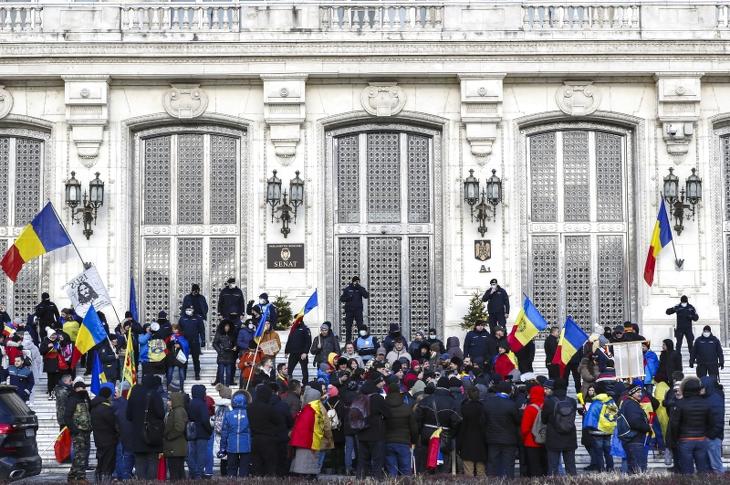 A Green Passnak nevezett védettségi igazolvány bevezetése ellen tüntetők a román parlament bukaresti épületénél, a szenátus bejárata előtti lépcsőkön, velük szemben rendőrök 2021. december 21-én (Fotó: MTI/EPA/Robert Ghement)
