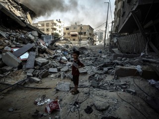 Egy kisfiú áll a romok közt Gázában az izraeli légicsapások után. Fotó: Twitter/UNRWA (az ENSZ palesztin menekültekkel foglalkozó ügynöksége)