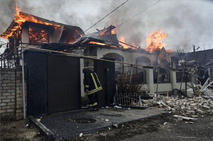 Orosz tüzérségi támadásban kigyulladt lakóháznál áll egy tűzoltó a dél-ukrajnai Herszonban 2023. január 6-án. Fotó: MTI/AP/Libkos
