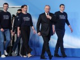 Duzzadó önbizalom: Vlagyimir Putyin érkezik fiatalokkal körülvéve moszkvai kampányközpontjába 2024. március 18-án. 